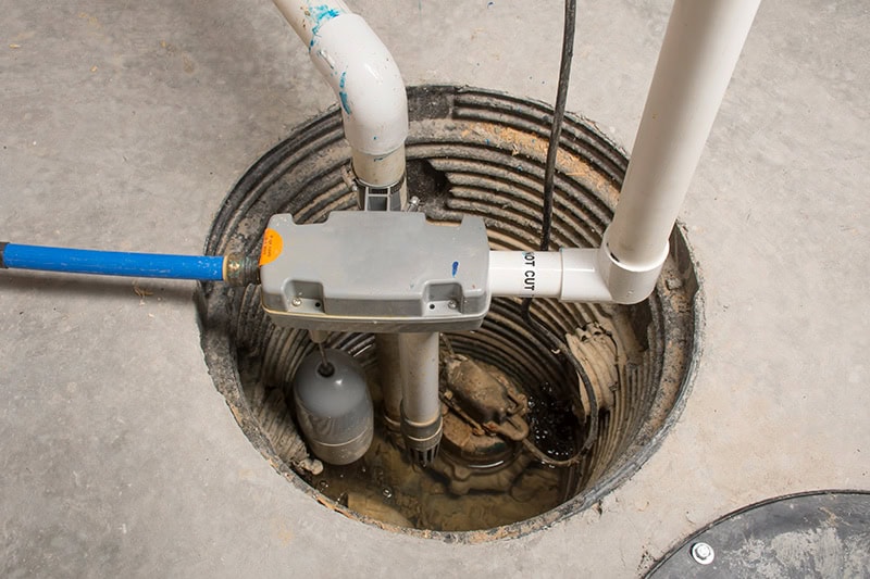 plumbing pipes going down a hole into the ground.